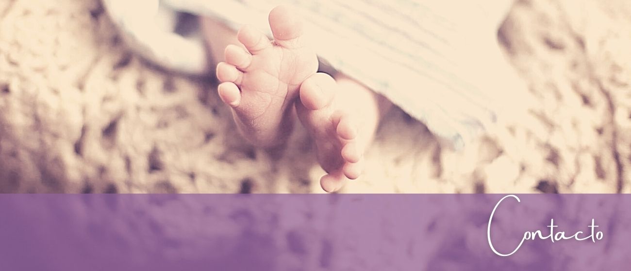 pies bebé descalzo, sobre colcha beige y franja violeta