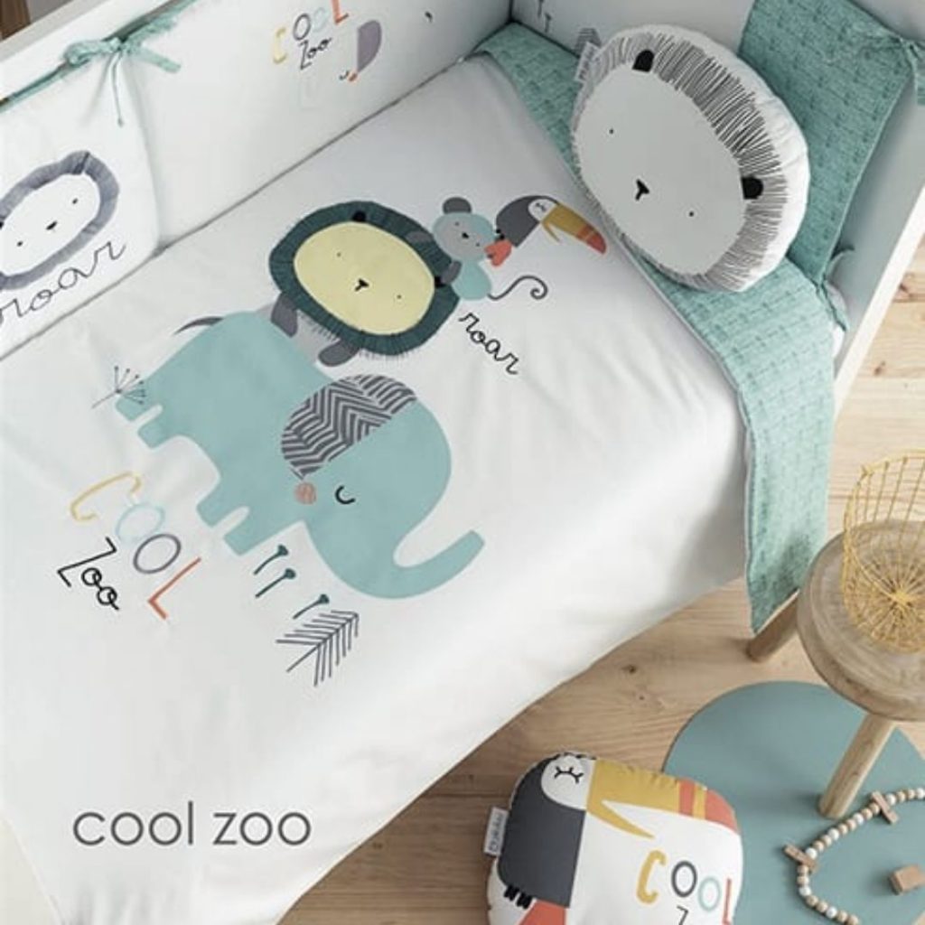 Textil para cuna con animales del zoo elefante tucán león en tonos azul pastel y blanco de la marca Bimbipirulos moda infantil
